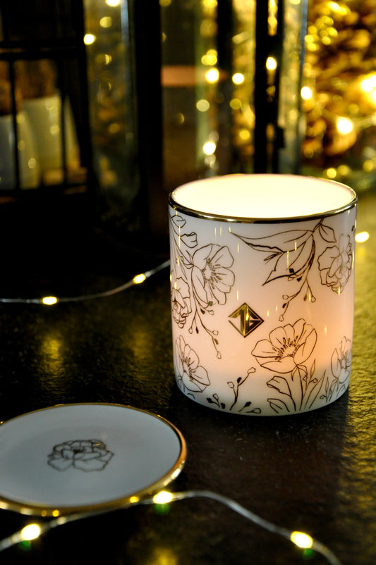 Lit Pepper & Vetiver candle glowing through translucent fine bone china with 22ct gold details