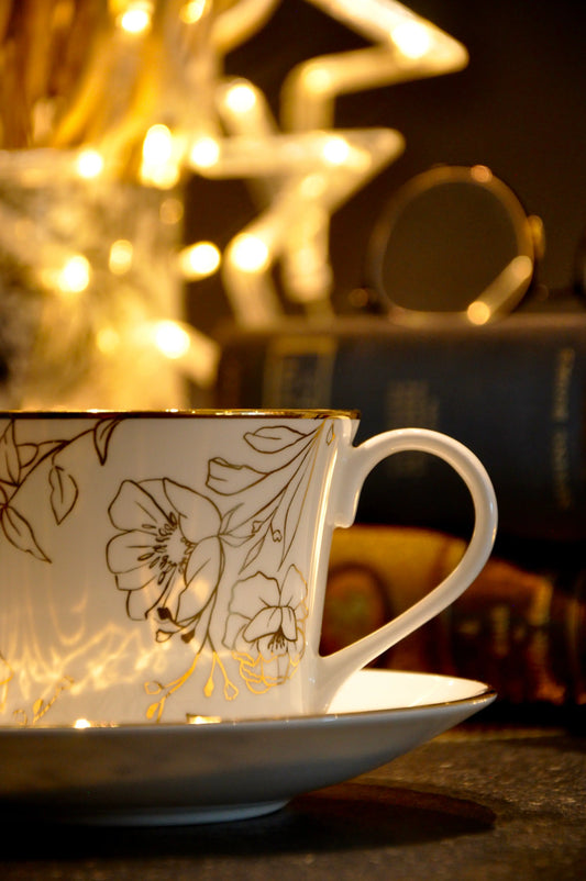 Blossom fine bone china cup and saucer with light highlighting the 22ct gold details in a warm interior