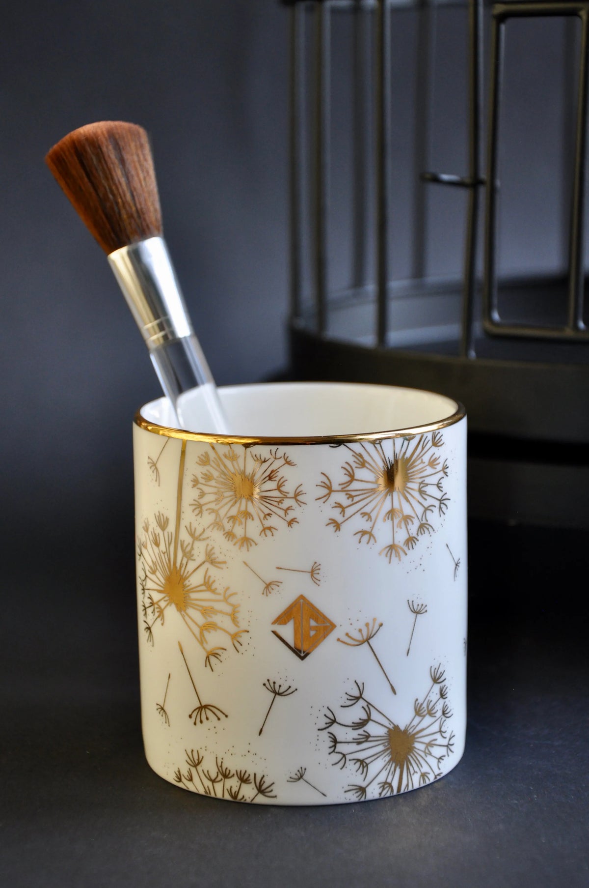 Gilded dandelion fine bone china pot holding a cosmetic brush 