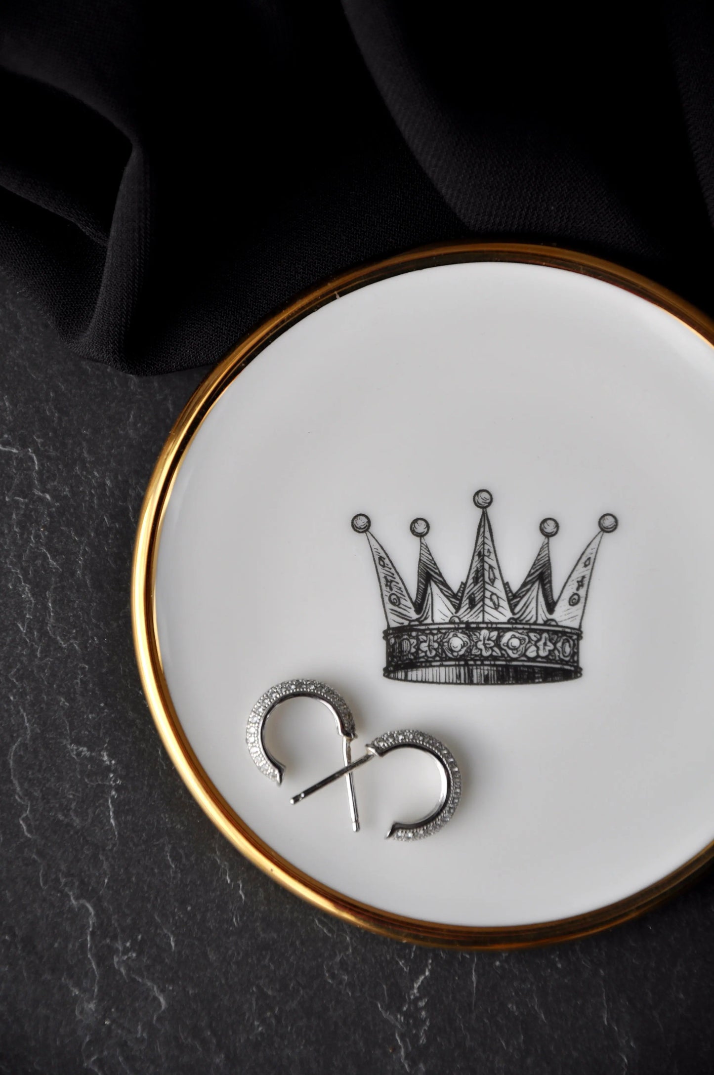 earrings placed inside a small fine bone china trinket dish